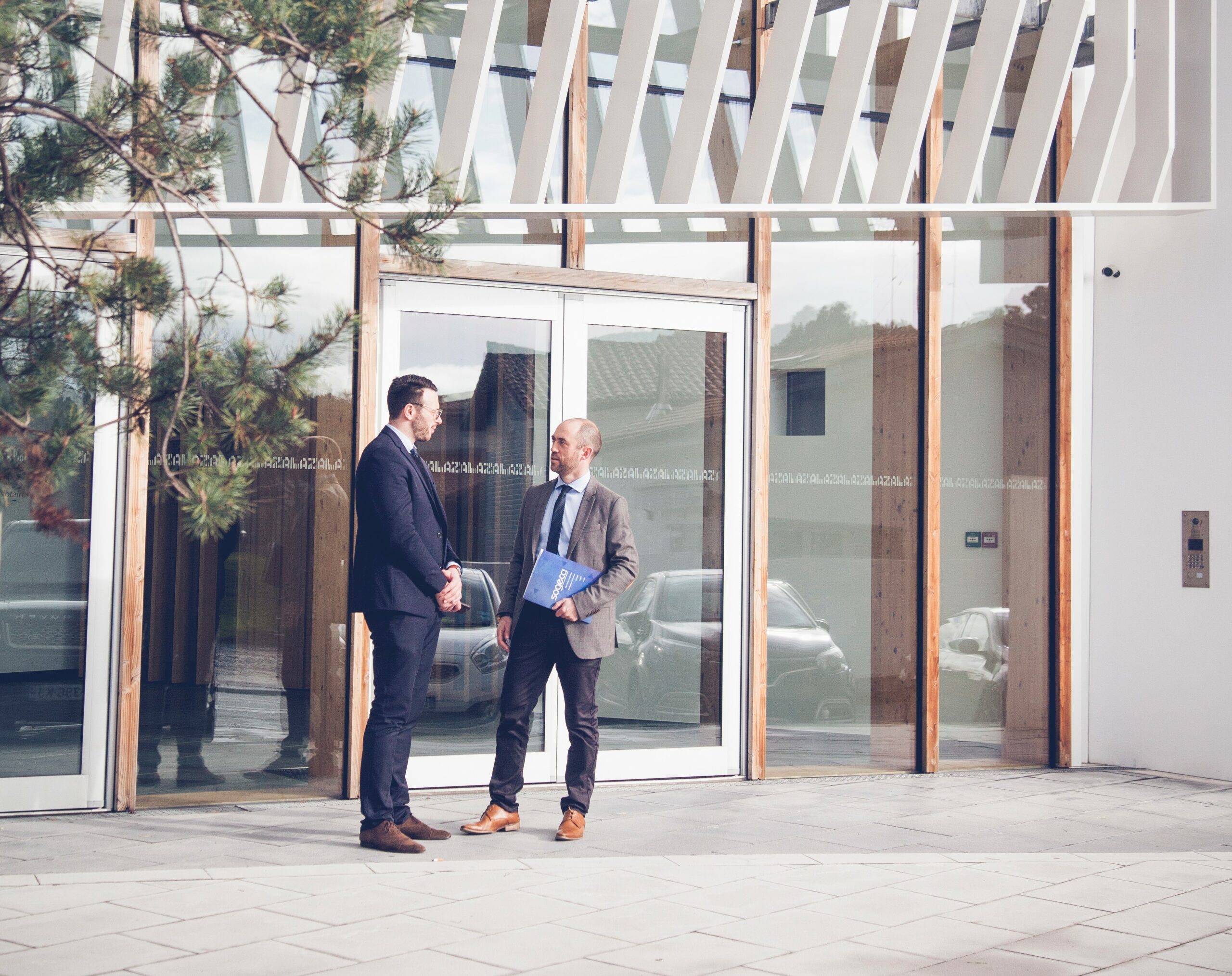 expertise comptable à biarritz, voici deux collaborateurs du cabinet d'expertise comptable sogeca de biarritz, qui discutent de comptabilité, gestion de la paie, audit, et fiscalité devant la porte du cabinet.